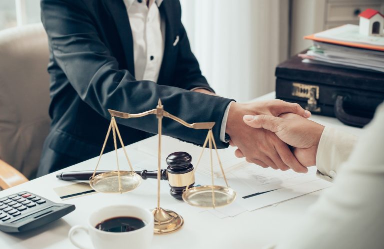 Businessman shaking hands to seal a deal with his partner lawyers or attorneys discussing a contract agreement